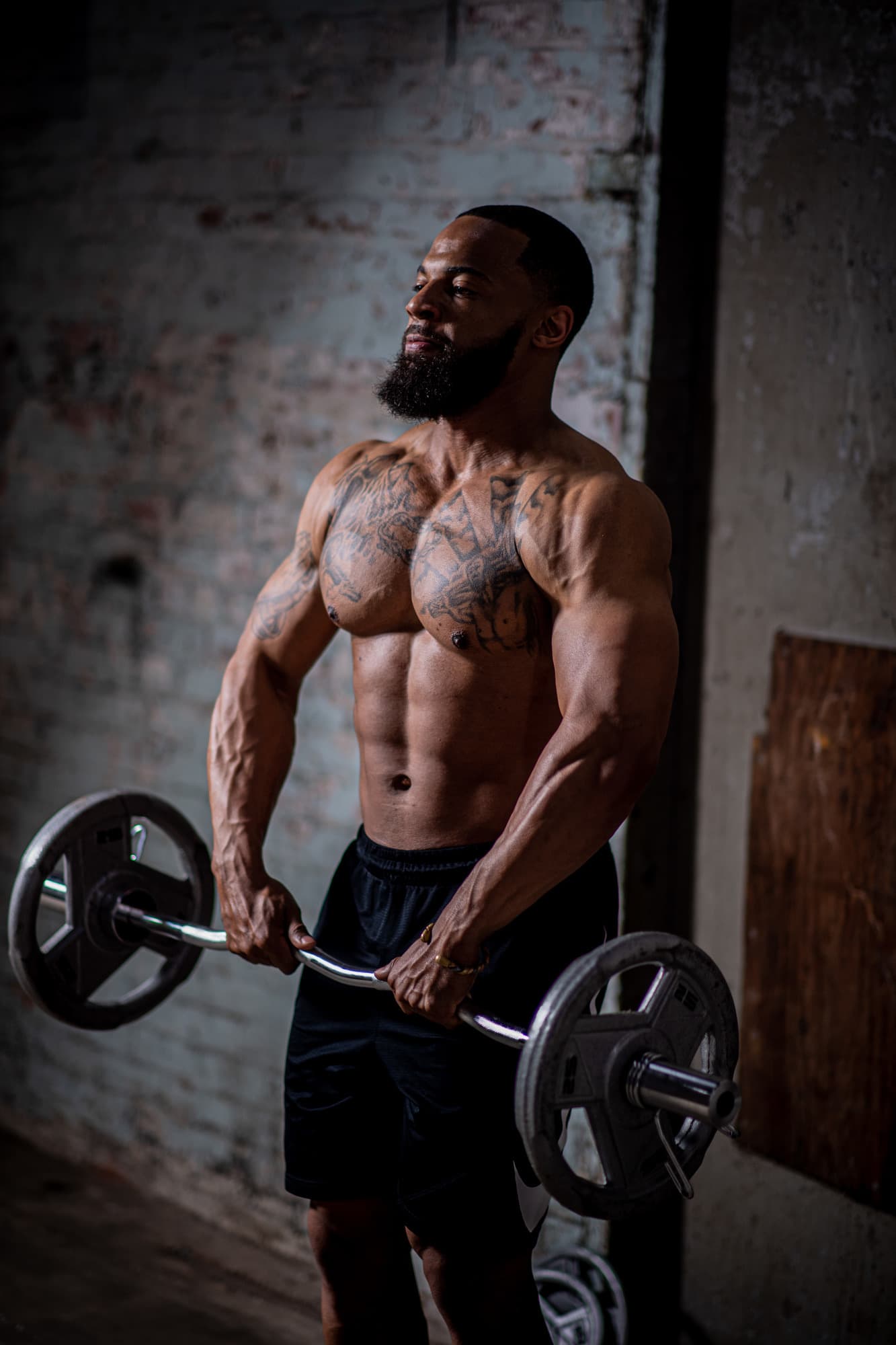 Chris Frazier mid-curl, lit from the side in a warehouse