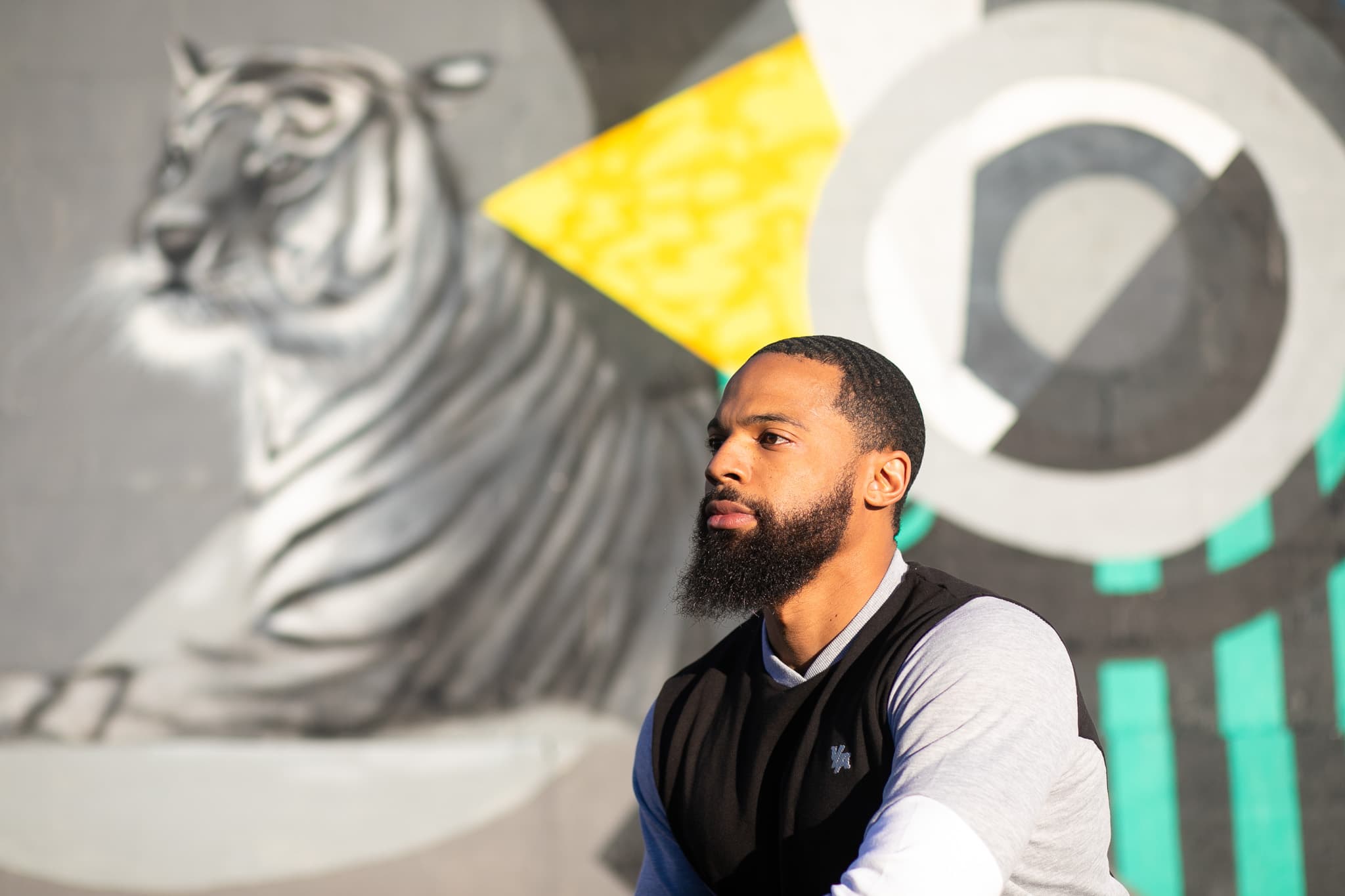 Chris Frazier in profile in front of a mural